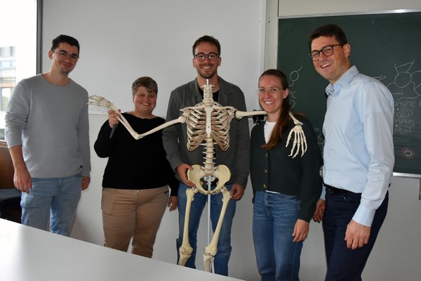Studierende und Professor mit Skelett