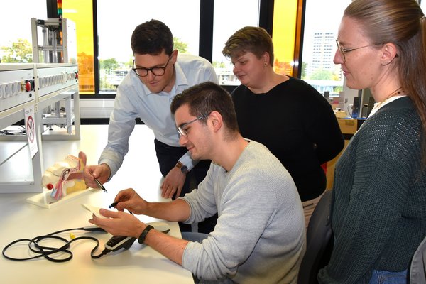Professor mit Studierenden im Labor.