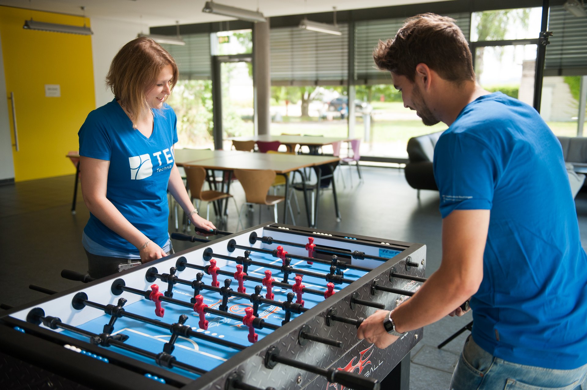 Studierende spielen Tischkicker.